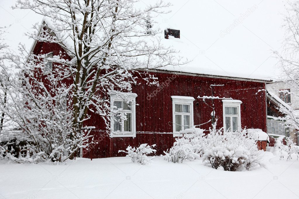 Winter rural landscape, house under snowfall