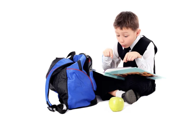Estudante com livro e maçã isolado em branco — Fotografia de Stock
