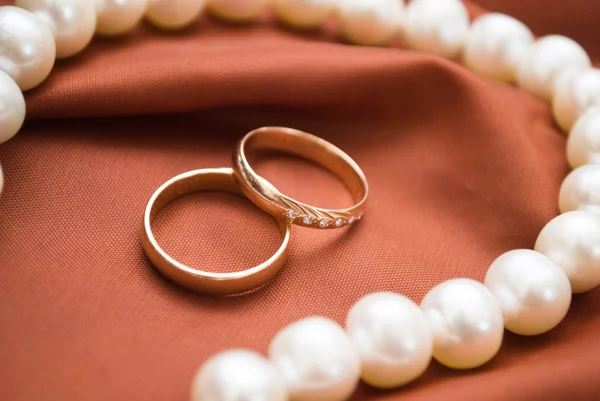 Pérolas brancas e anéis de casamento — Fotografia de Stock