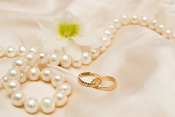 Weiße Perlen und Trauringe Stockbild