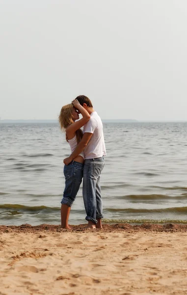 Couple embrace on a beach — Stock Photo, Image
