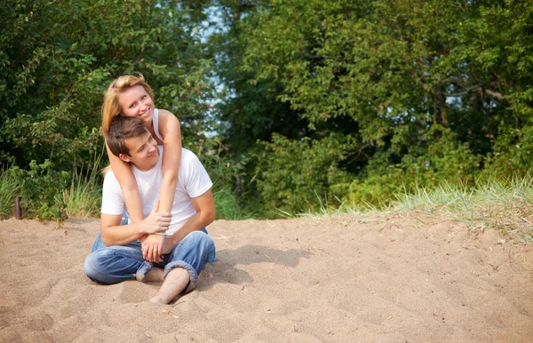 Casal sentado em uma areia — Fotografia de Stock
