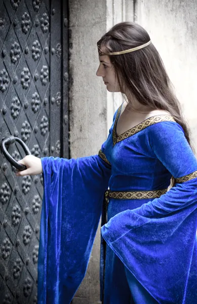 Medieval girl opening door — Stock Photo, Image