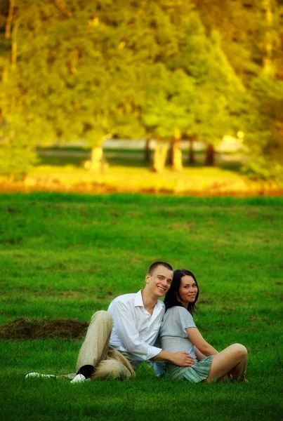 Couple sitting on park lawn — Stock Photo, Image