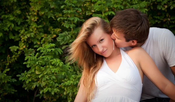 Man kiss sly girl in cheek — Stock Photo, Image