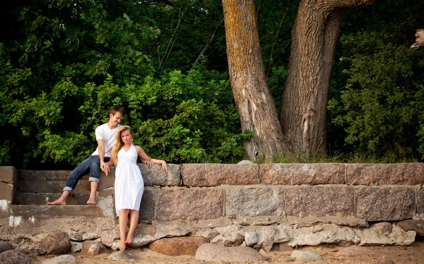 Couple stand next stonewall in forest — Stock Photo, Image