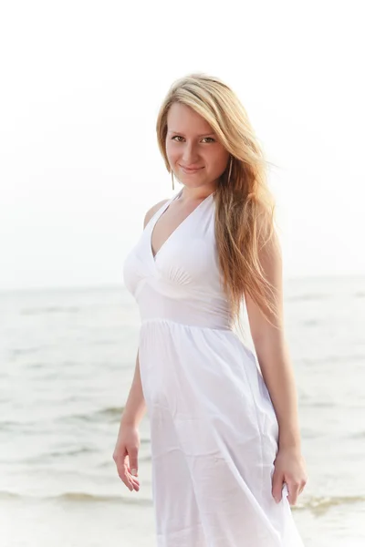Beautiful woman standing on seashore — Stock Photo, Image