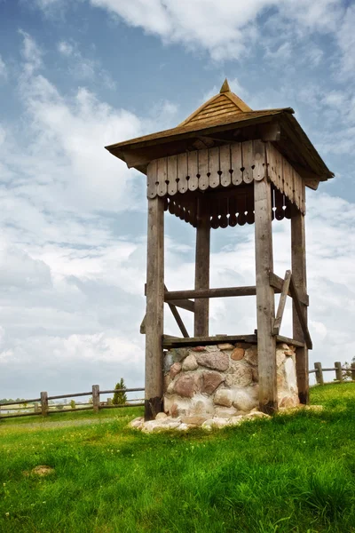 Village well on green hill — Stock Photo, Image