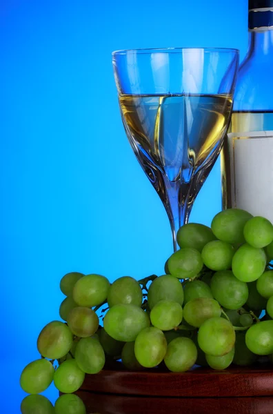 Glass 的葡萄酒和葡萄群 蓝色背景 — 图库照片