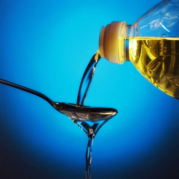 Pouring Olive Oil Spoon Blue Background — Stock Photo, Image