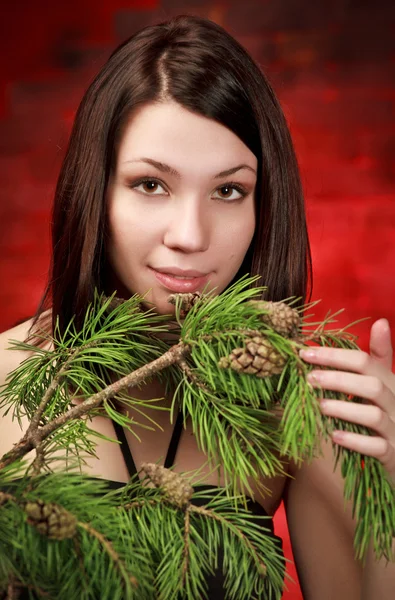 Krásná Dívka Borové Větve Červené Pozadí — Stock fotografie