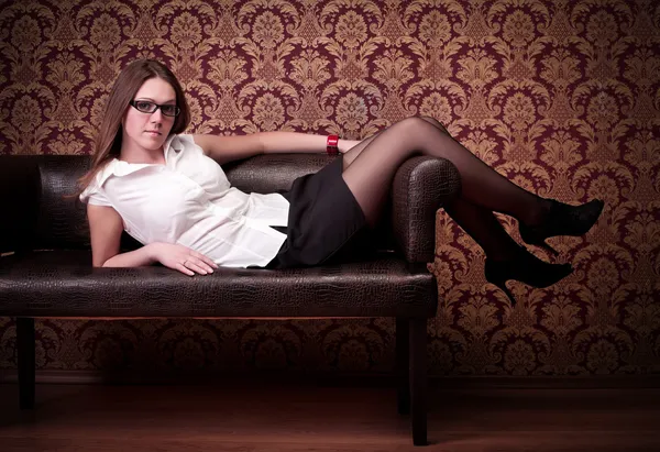 美しい女の子がソファの上に敷設 — ストック写真