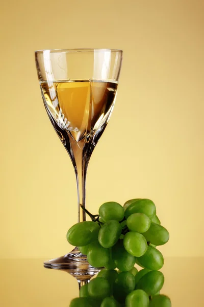 Glass 的葡萄酒和葡萄串 米色背景 — 图库照片