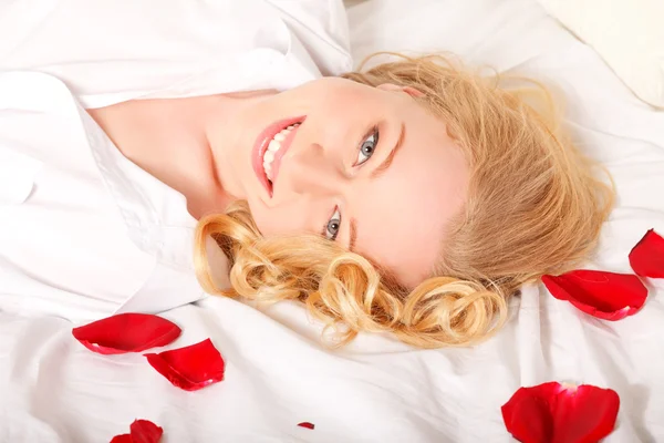 Glada Blonda Kvinnan Sängen Med Röda Rosenblad — Stockfoto