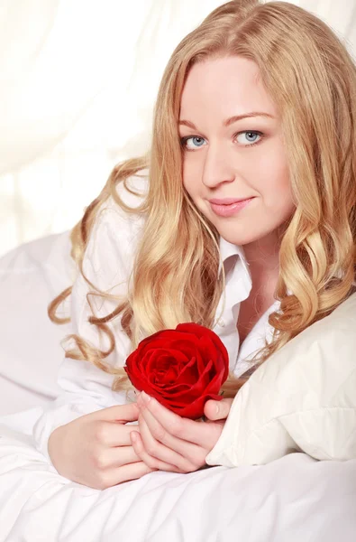 躺在床上与红玫瑰的漂亮女孩 — 图库照片