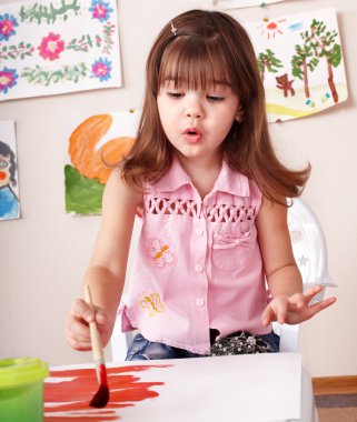 Child paint picture in preschool. clipart