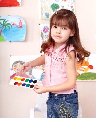 Child with paint in art class . clipart