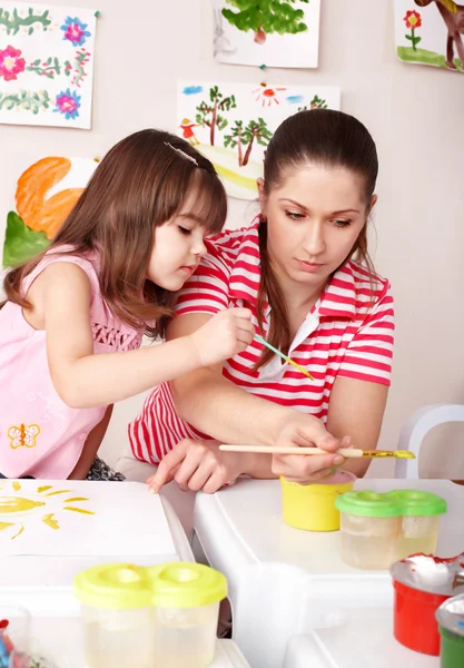 Child painting with teacher in preschool. — Stock Photo, Image