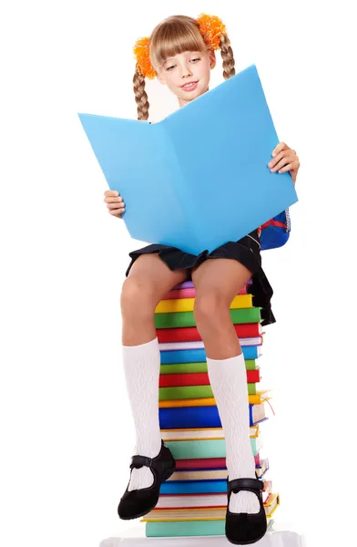 Školačka sedí na hromadě knih. — Stock fotografie