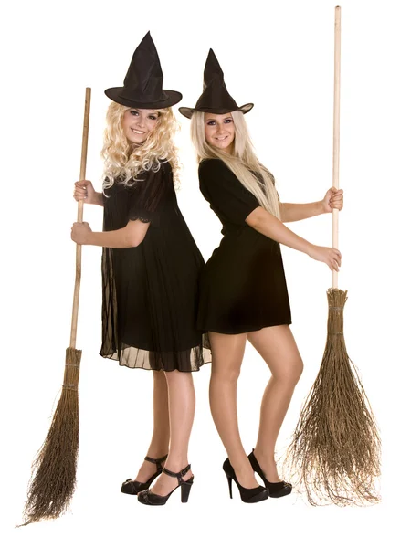 Dvě čarodějnice halloween v černých šatech a klobouk na koštěti. — Stock fotografie