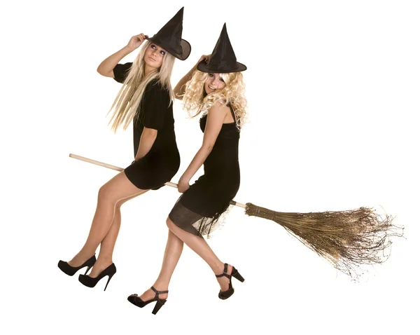Two Halloween witch blond in black dress and hat on broom. — Stock Photo, Image