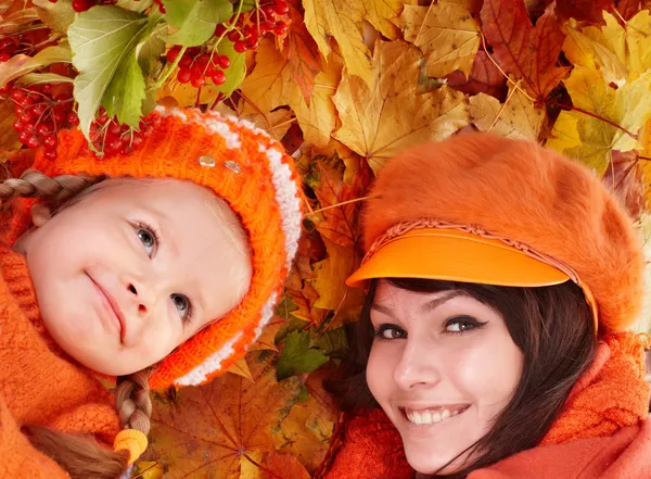 Glückliche Familie mit Kind auf herbstorangefarbenen Blättern. — Stockfoto