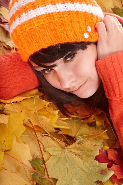 Mädchen mit orangefarbenem Hut auf Blättern mit traurigem Gesicht. — Stockfoto
