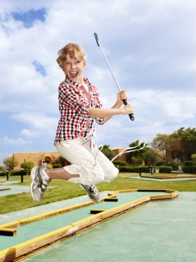 Little girl playing golf in park. clipart