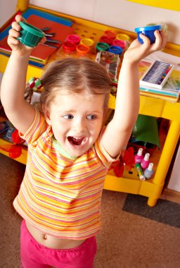 Child with paint in play room. clipart