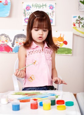 Child paint picture in preschool. clipart