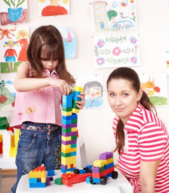 Child with Lego block and construction set in play room. clipart