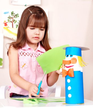 Serious child cutting paper. clipart