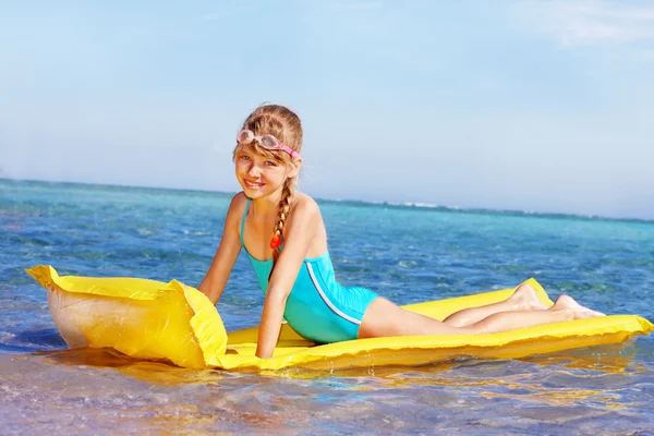 Kind schwimmt aufblasbare Strandmatratze. — Stockfoto