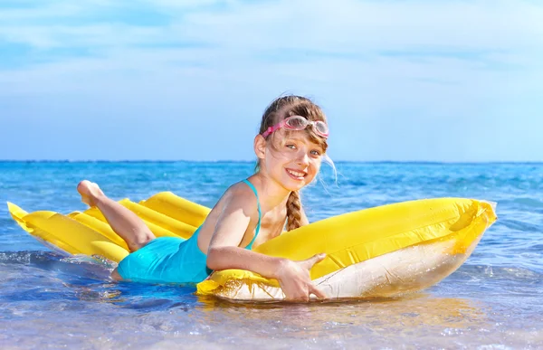Kind schwimmt auf aufblasbarer Strandmatratze. — Stockfoto