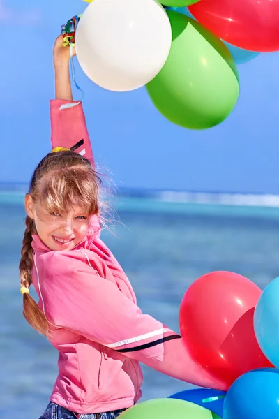 Kind spielt mit Luftballons am Strand. — Stockfoto