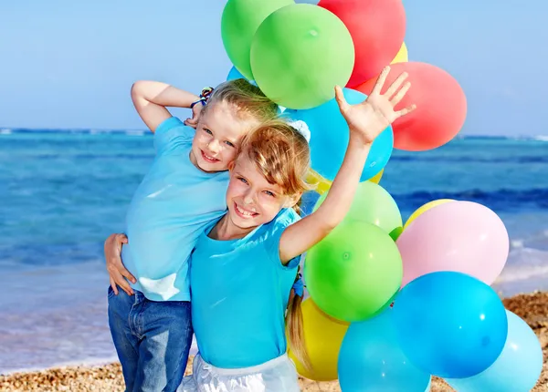 Bambini che giocano con i palloncini in spiaggia — Foto Stock