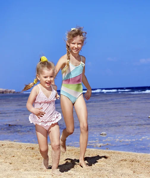 Niños tomados de la mano caminando por la playa . — Foto de Stock