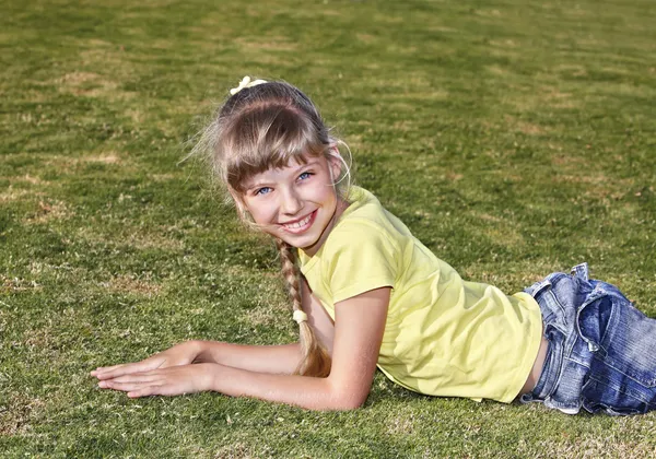 Παιδί που βρίσκεται στο πράσινο γρασίδι . — Φωτογραφία Αρχείου