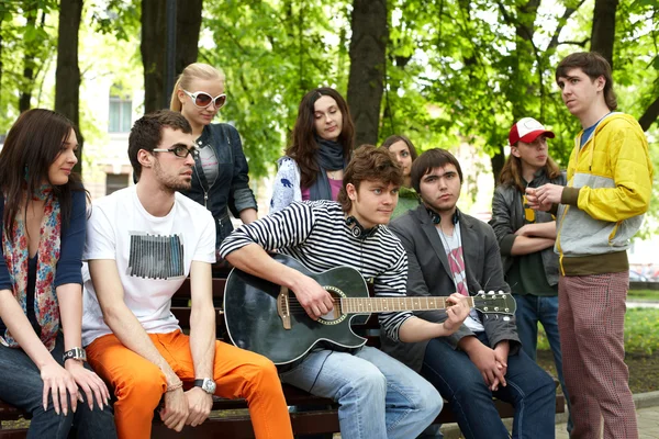 Group of in city park listen music. — Stock Photo, Image