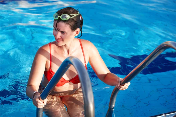 Vrouw in sport brillen bladeren zwembad. — Stockfoto