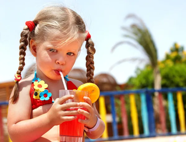 Gadis kecil berkacamata dan bikini merah minum jus . — Stok Foto