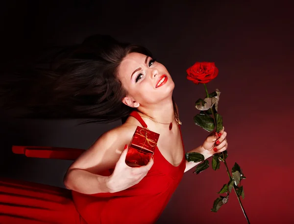 Dívka s květ růže a dárkový box běží. — Stock fotografie