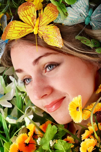 Όμορφη κοπέλα με πεταλούδων και λουλουδιών για την πράσινη χλόη. — Φωτογραφία Αρχείου