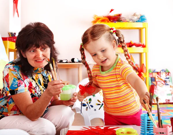 Dítě s učitelem kreslení barvy v herně. — Stock fotografie