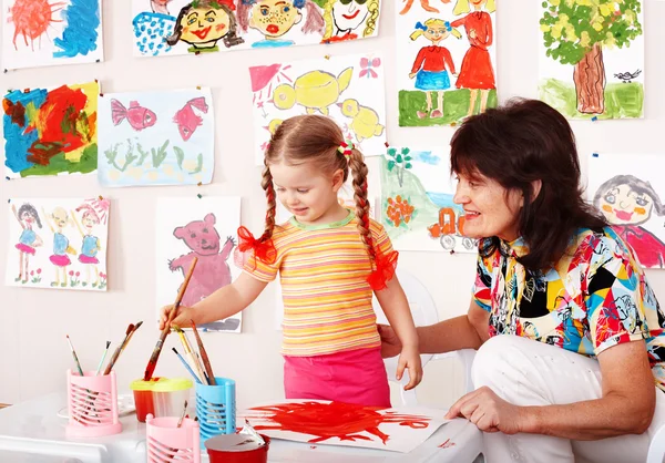 Child with teacher draw paints in playroom. — Stock Photo, Image