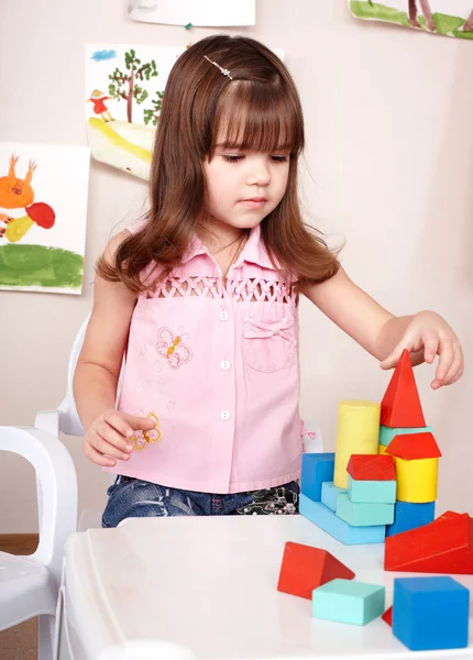 Kind spelen met hout blok in kamer. — Stockfoto