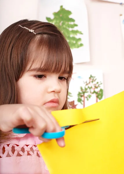 Serious child cutting paper. — Stok fotoğraf