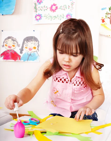 Child with scissors cut paper in play room. — Stock Photo, Image