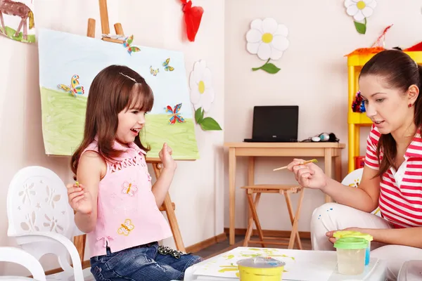 Gyermek a tanár felhívja a festékek játék szoba. — Stock Fotó