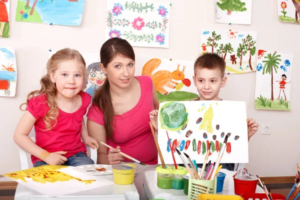 Barn målar med lärare i konst klass. — Stockfoto